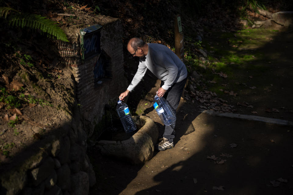 Joan Torrent, 64, fills plastic jugs at a natural spring in Gualba, about 50 km, (31 miles) northwest of Barcelona, Spain, Wednesday, Jan 31, 2024. Joan trudges almost every day into the woods in search of drinking water. Spain's northeast Catalonia is preparing to declare a drought emergency for the area of some six million people including the city of Barcelona. But thousands of people who live in villages and towns in the Catalan countryside have already been in full-blown crisis mode for several months. (AP Photo/Emilio Morenatti)