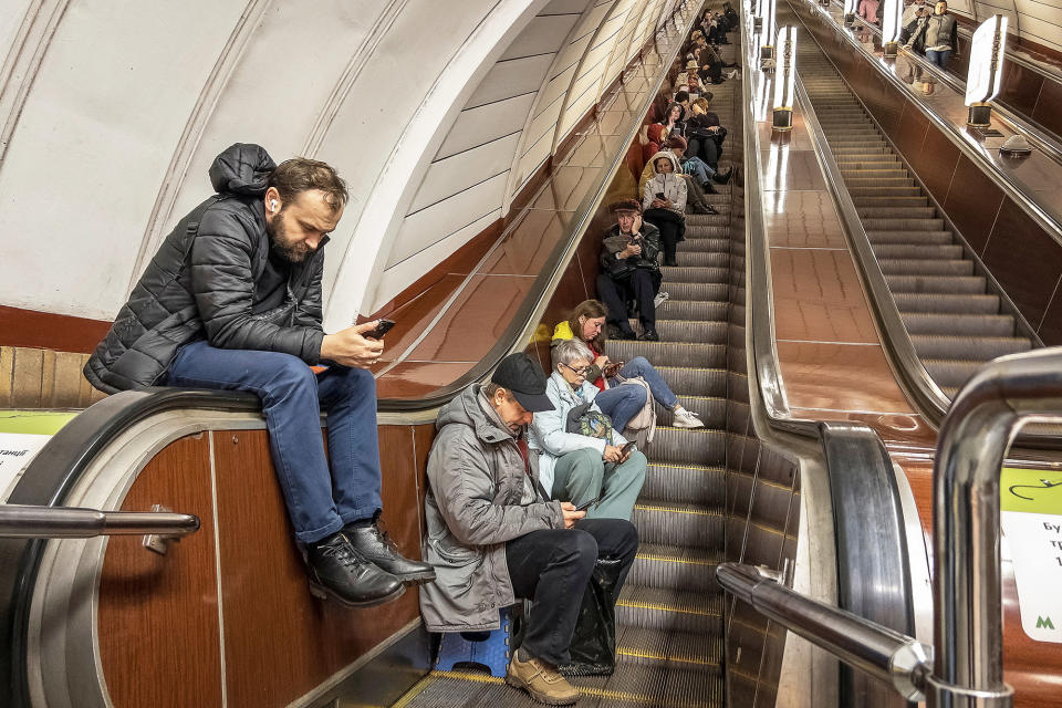People sitting down and waiting on an escalator