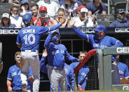 Toronto Blue Jays' Marcus Semien (10) is congratulated after scoring in the ninth inning of a baseball game against the Atlanta Braves Thursday, May 13, 2021, in Atlanta. Semien scored on a double by Blue Jays' Bo Bichette. (AP Photo/Ben Margot)