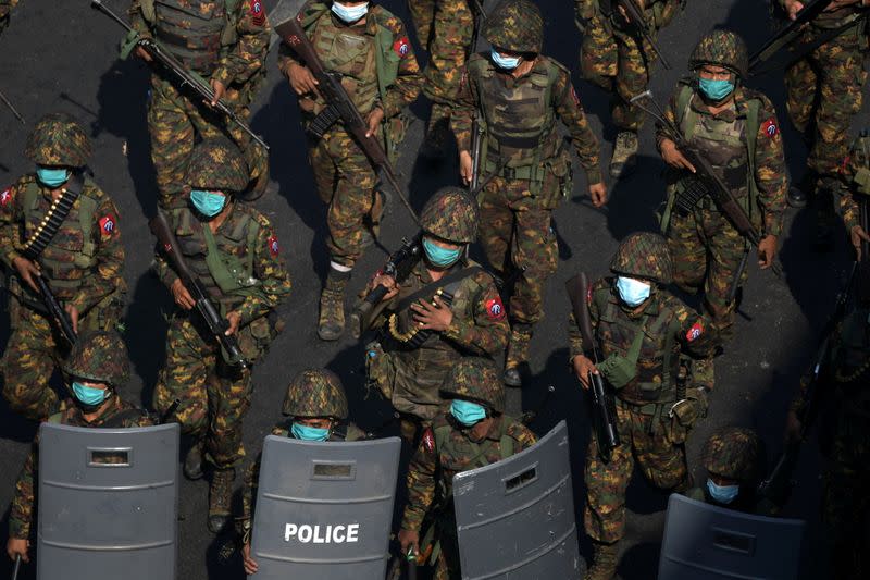 Myanmar soldiers walk along a street during a protest against the military coup in Yangon