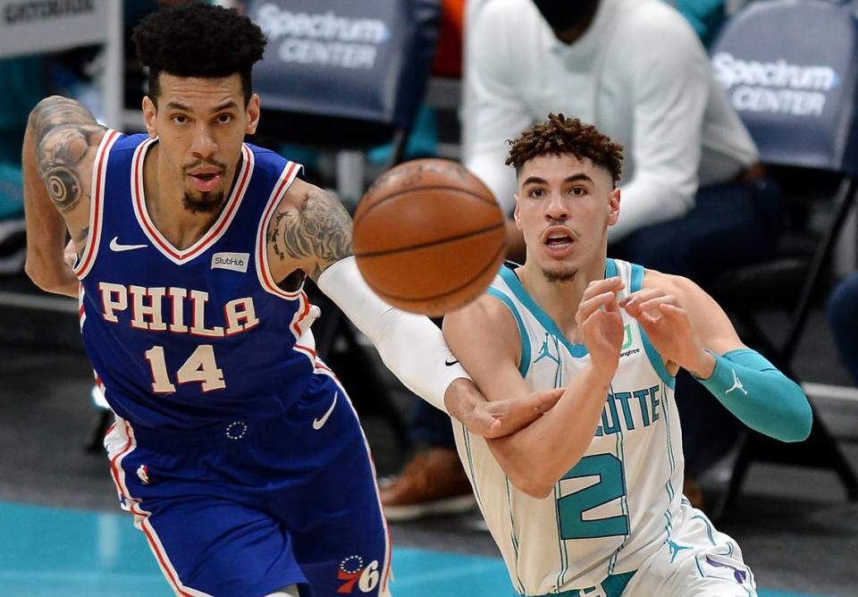 Charlotte Hornets guard LaMelo Ball, right, passes to a teammate as Philadelphia 76ers guard Danny Green, left, chases him on Feb. 3rd.