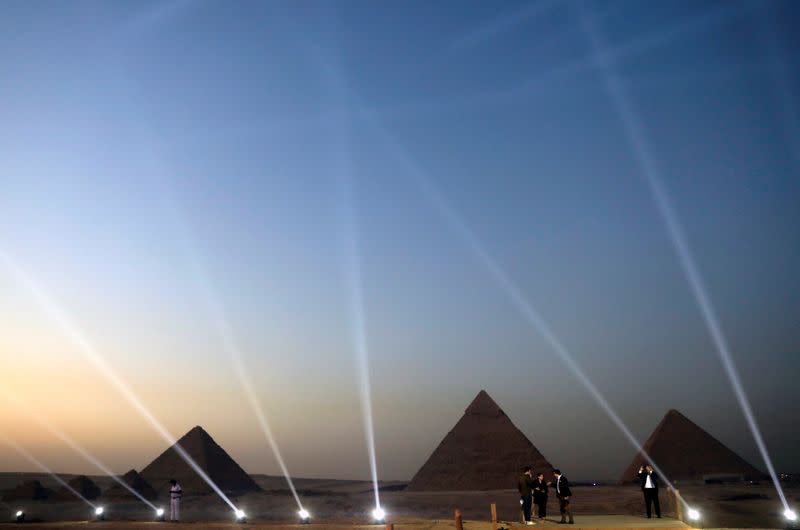 FILE PHOTO: People take pictures in front of the Great Pyramids in Giza