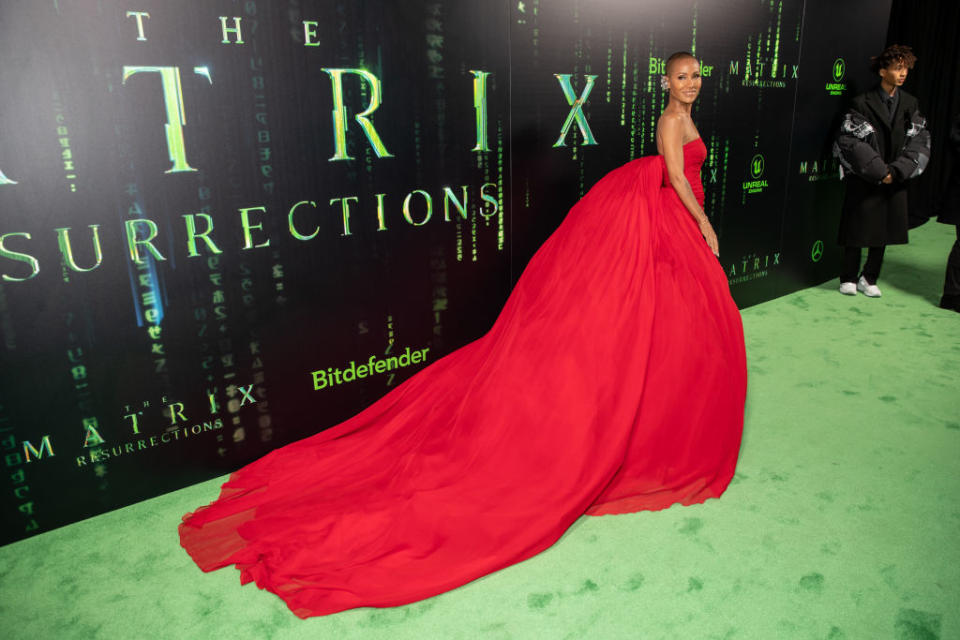 Jada Pinkett Smith arrives at the premiere of The Matrix Resurrections in an incredible fiery red gown with oversized train. (Getty Images)