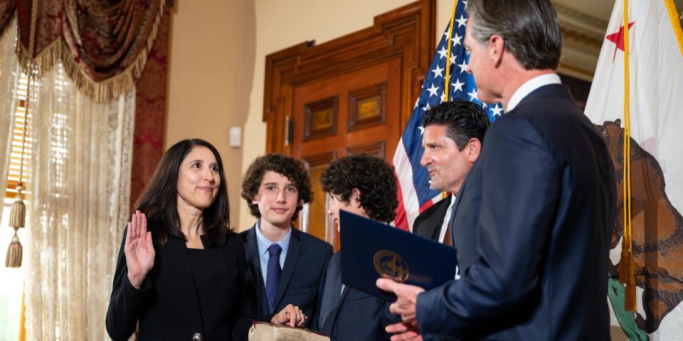 Patricia Guerrero, left, is sworn-in to the California Supreme Court on Monday, March 28, 2022, by Gov. Gavin Newsom at the Stanford Mansion in Sacramento. She is joined by her sons Anthony, 15, left, and Christopher, 14, holding a family Bible, and her husband, Joe Dyson. Guerrero is the first Latina justice on the state's highest court.