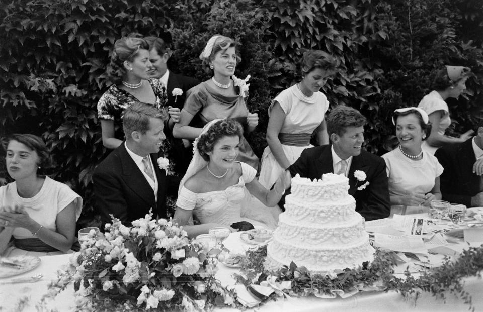 View of the head table of at the Kennedy wedding reception, Newport, Rhode Island, September 12, 1953. Among those pictured are Robert Kennedy (1925 - 1968) (seated, second left), bride Jacqueline Kennedy (1929 - 1994) (seated, center) (in a Battenburg wedding dress), groom and future US President John F Kennedy (1917 - 1963) (seated second, right); standing behind them is Eunice Kennedy Shriver (1921 - 2009). (Photo by Lisa Larsen/Time & Life Pictures/Getty Images)