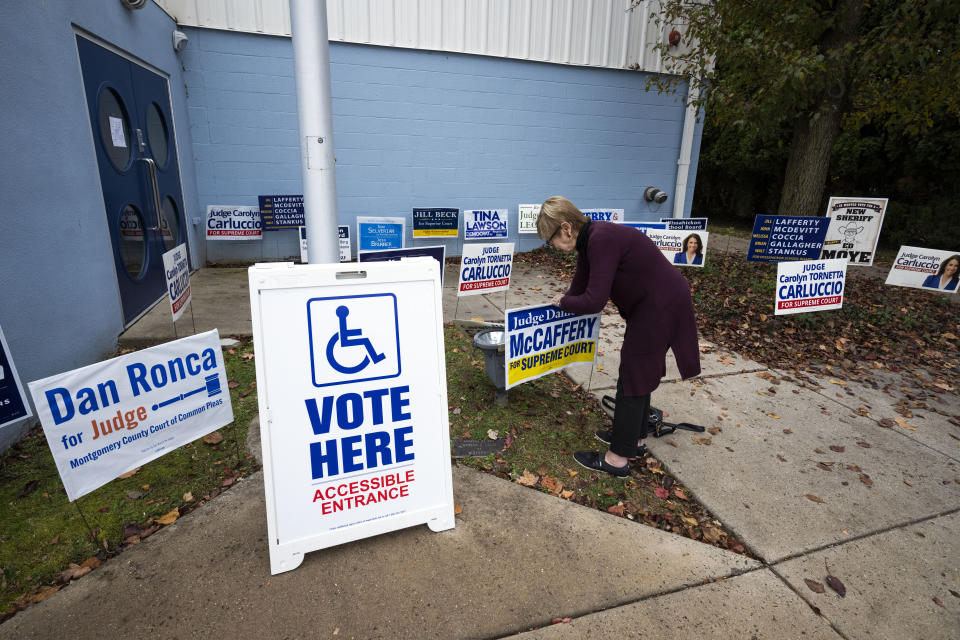 Signs are adjusted on Election Day at the Wissahickon Valley Public Library in Blue Bell, Pa. on Tuesday, Nov. 7, 2023. (AP Photo/Joe Lamberti)