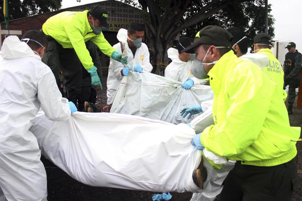 Policemen and members of the forensic team carry the bodies of members of the FARC in Cucuta