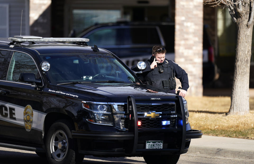 A police officer talks on a mobile device outside the Legacy Assisted Living at Lafayette care facility, Wednesday, Feb. 3, 2021, in Lafayette, Colo. A 95-year-old resident of the assisted care home was taken into police custody Wednesday after allegedly shooting an employee at the center. (AP Photo/David Zalubowski)