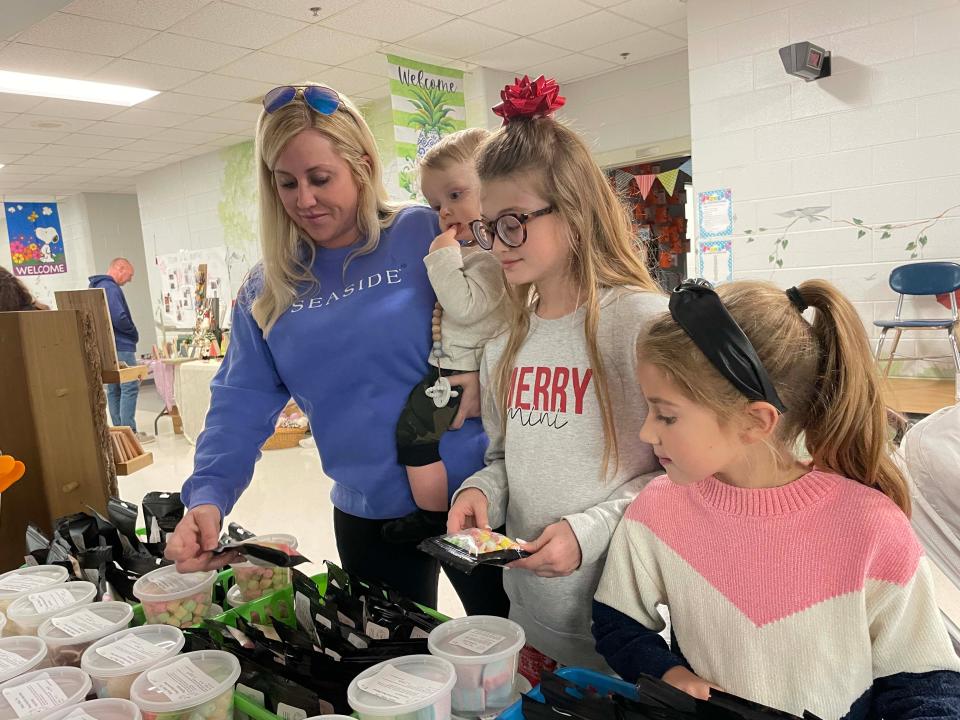 Amanda Flenniken shops with her kids Nash,1; Sophia, 11; and Brooklie, 7, at a booth featuring homemade freeze dried candies.