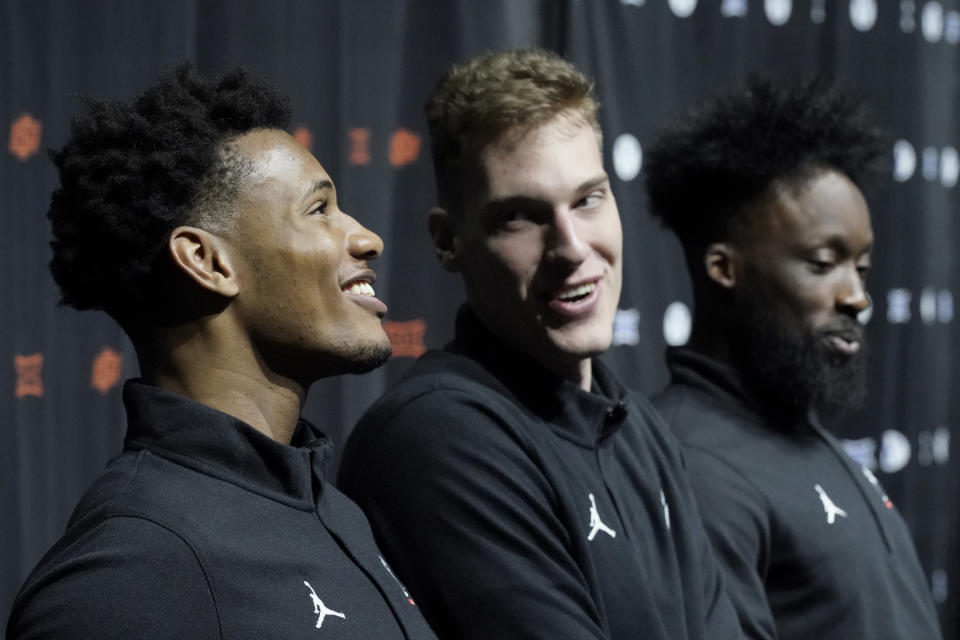 Cincinnati's Ody Oguama, left speaks while Viktor Lakhin, center, and John Newman III look on during the NCAA college Big 12 men's basketball media day Wednesday, Oct. 18, 2023, in Kansas City, Mo. (AP Photo/Charlie Riedel)