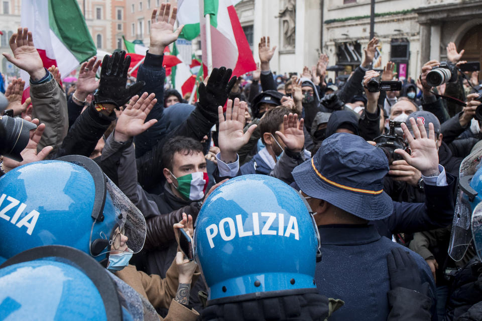 Demonstrators of the "Io apro" (I open) movement face police during a protest against restriction measures to curb the spread of COVID-19, in Rome, Monday, April 12, 2021. Italian restaurant owners from all over Italy and others angry at having their businesses shut for weeks due to a virus lockdown scuffled with police Monday during a non-authorized protest nearby the Parliament in Rome. (Roberto Monaldo/LaPresse via AP)