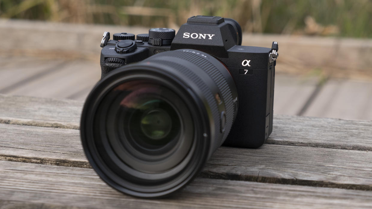  The Sony A7 IV camera sitting on a wooden bench. 
