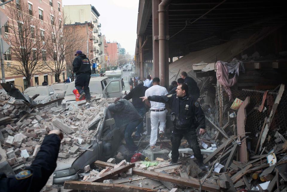 Police respond to the scene of an explosion and building collapse in the East Harlem neighborhood of New York, Wednesday, March 12, 2014. The explosion leveled two apartment buildings, and sent flames and billowing black smoke above the skyline. (AP Photo/Jeremy Sailing)