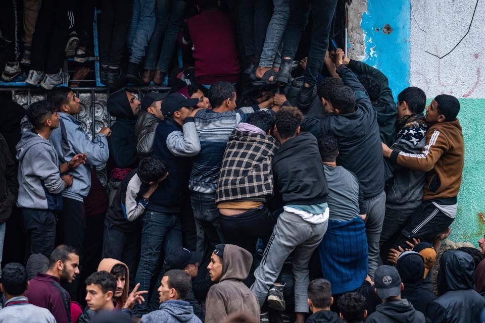 Palestinian crowds struggle to buy bread from a bakery in Rafah, Gaza Strip, Sunday, Feb. 18, 2024. International aid agencies say Gaza is suffering from shortages of food, medicine and other basic supplies as a result of the war between Israel and Hamas. (AP Photo/Fatima Shbair)