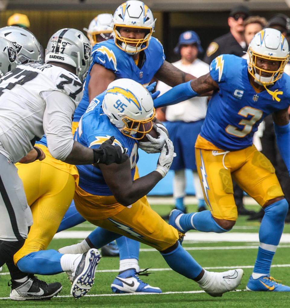 Chargers defensive tackle Poona Ford (95) intercepts a pass tipped by teammate Khalil Mack to seal a win over the Raiders.