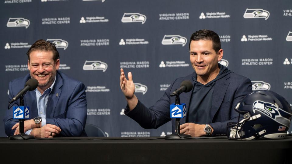 Seattle Seahawks NFL football team new head coach Mike Macdonald, right, answers a reporter's question while general manager John Schneidner laughs during an introductory press conference, Thursday, Feb. 1, 2024, in Renton.