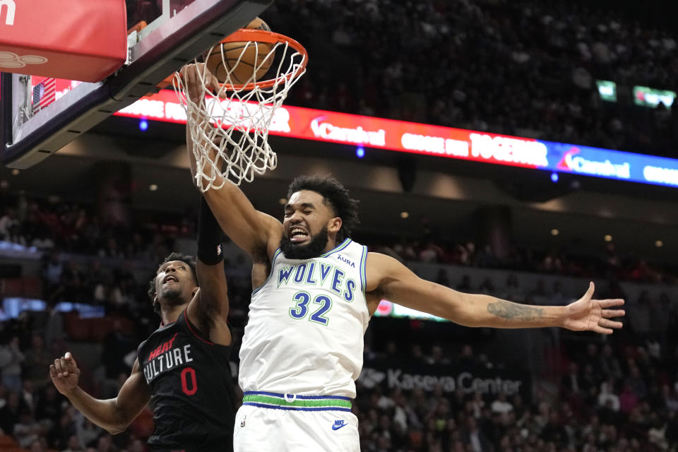 Minnesota Timberwolves center Karl-Anthony Towns (32) goes to the basket and is fouled by Miami Heat guard Josh Richardson (0) during the first half of an NBA basketball game, Monday, Dec. 18, 2023, in Miami. (AP Photo/Lynne Sladky)