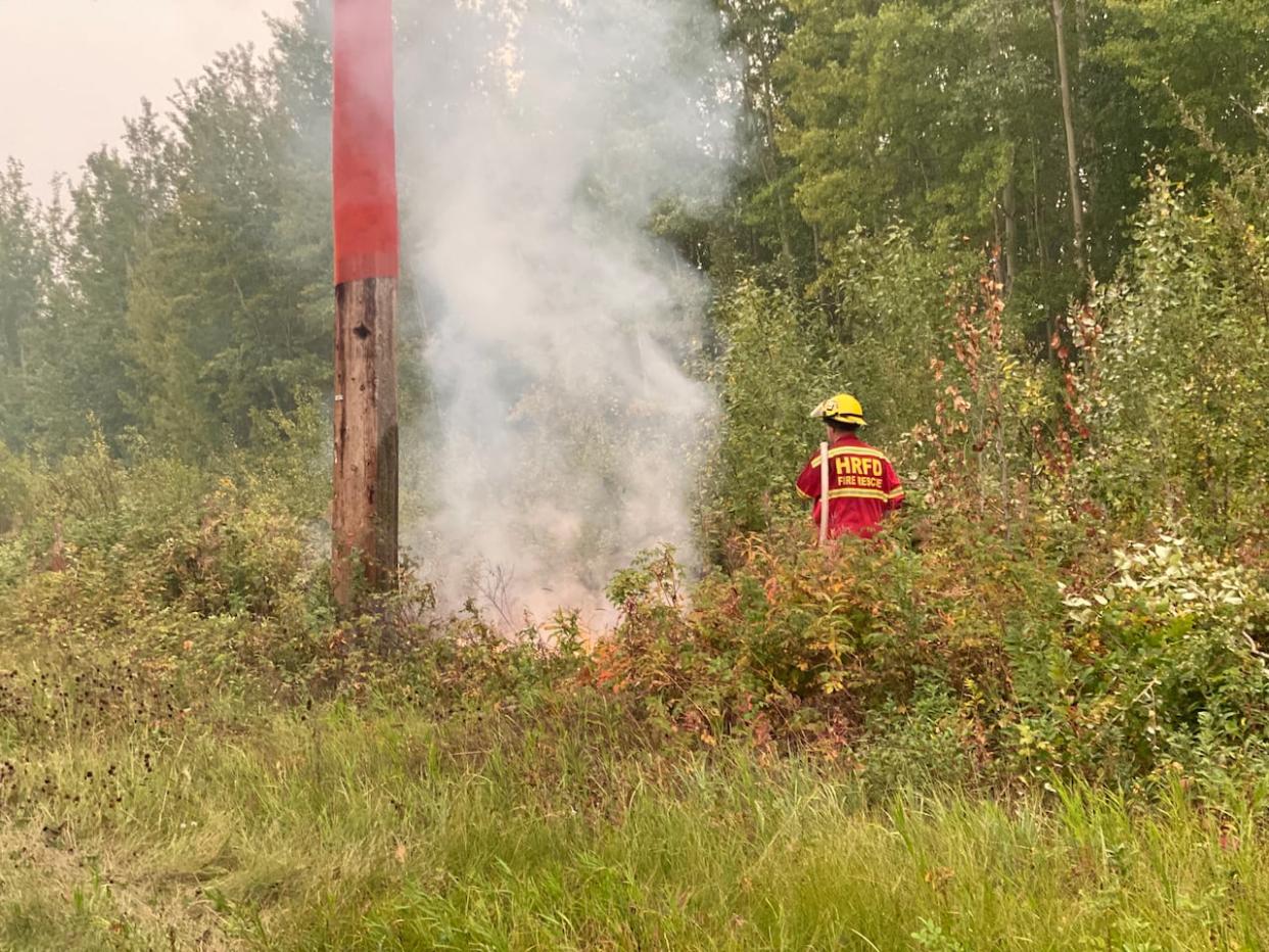 A firefighter near a wildfire hotspot in Hay River, posted on Facebook by N.W.T. Fire on Wednesday. N.W.T. Fire information officer Mike Westwick said there is potential for serious firefighting challenges in Hay River, N.W.T., on Friday because of strong winds expected to blow the fire toward the community.   (Submitted by N.W.T. Fire - image credit)