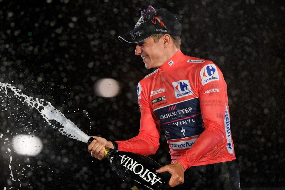 Remco Evenepoel spray champagne on the winner’s podium in Madrid (AFP via Getty Images)