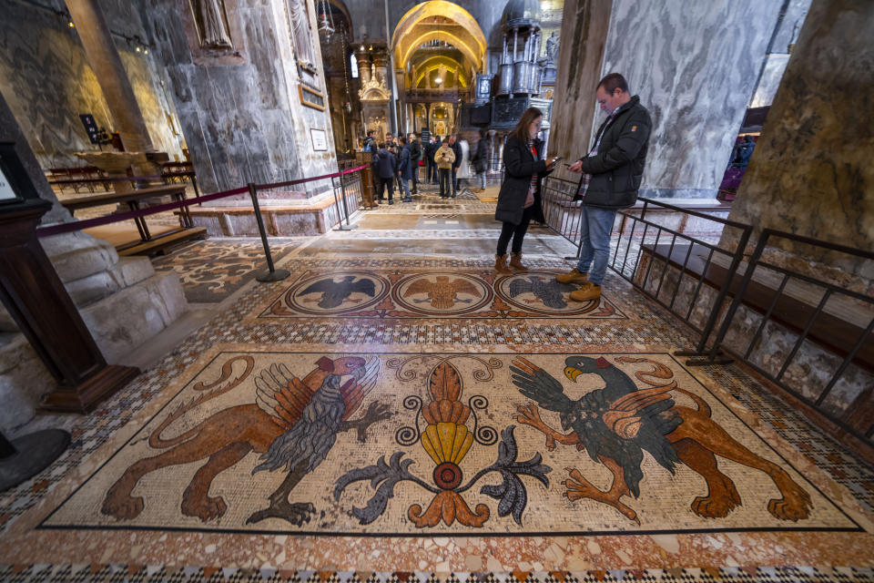 Belt barriers limit visitors' circulation on the fragile marble mosaics on the floor of St. Mark's Basilica endangered for centuries by seawaters in Venice, northern Italy, Wednesday, Dec. 7, 2022. Glass barriers that prevent seawater from flooding the 900-year-old iconic Venice's Basilica during high tides have been recently installed around it. St. Mark's Square is the lowest-laying city area and frequently ends up underwater during extreme weather. (AP Photo/Domenico Stinellis)