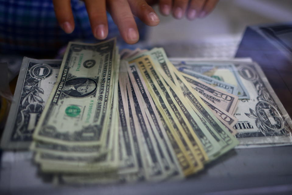 El empleado de una tienda de cambio de moneda cuenta billetes de dólares estadounidenses en Ciudad Juárez, México, 27 de julio de 2023. REUTERS/José Luis González