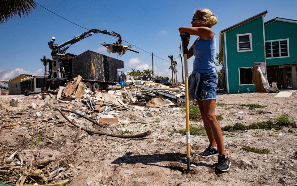 Almost six months after Hurricane Ian decimated Fort Myers Beach, Marilea Reed, a property owner on Fort Myers Beach pauses while cleaning her yard on Monday, March 13, 2023. She plans on waiting a bit but is rebuilding. She says this is one of the toughest things she has been through in her life.