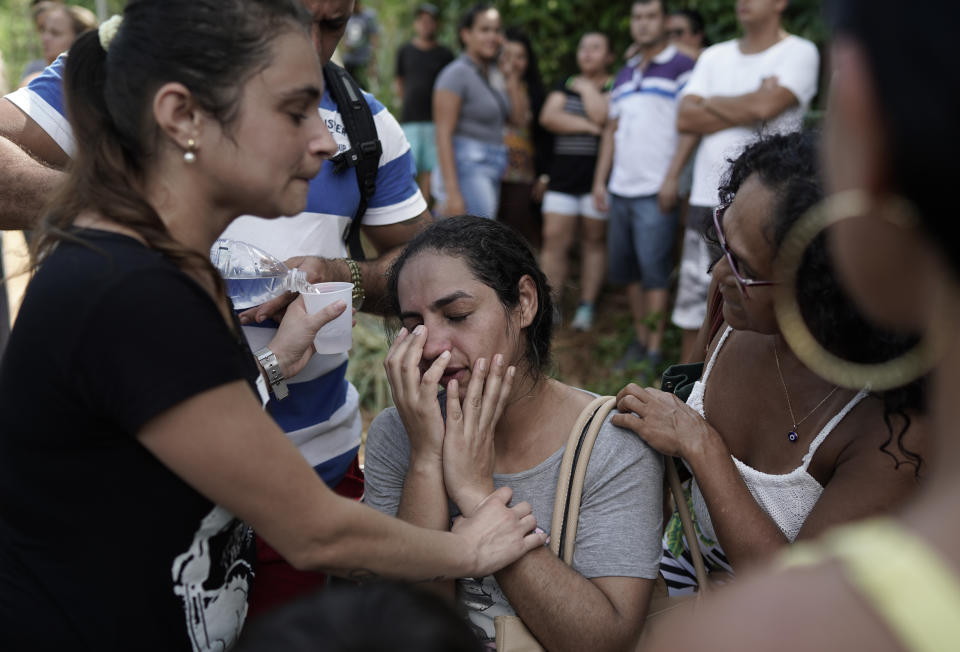 Residents react with relief after learning that their relatives are survivors of the two collapsed buildings in the Muzema neighborhood, Rio de Janeiro, Brazil, Friday, April 12, 2019. The collapse came in a western part of the city that was particularly hard hit by heavy rains this week that caused massive flooding. (AP Photo/Leo Correa)