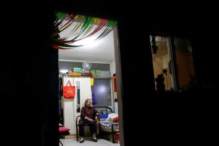 Migrant Mrs Zhong watches TV in her one room home at the outskirts of Beijing, China October 1, 2017. Picture taken October 1, 2017. REUTERS/Thomas Peter