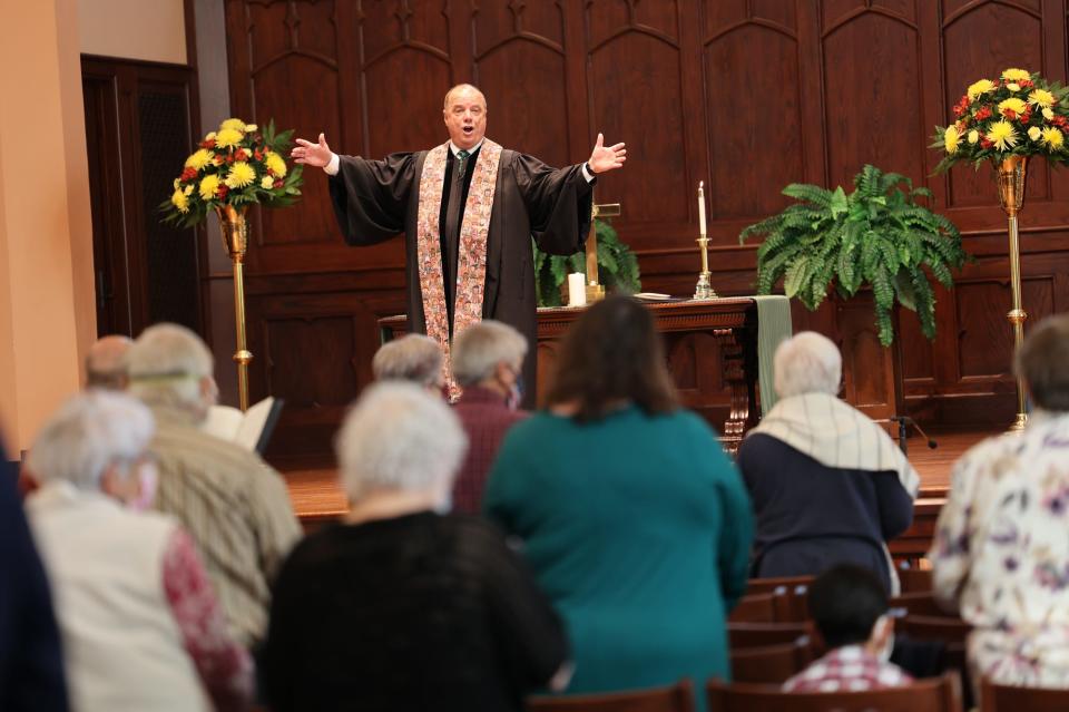 FILE - Rev. Billy Hester leads the congregation as they sing a hymn during Sunday service at Asbury Memorial.