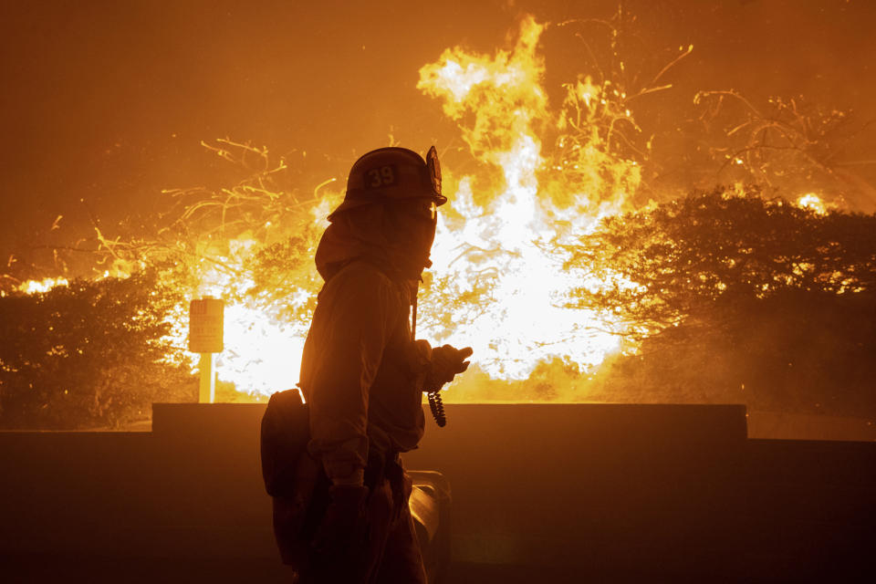 In this Thursday, Oct. 10, 2019 photo, a firefighter monitors the Saddleridge fire near homes in Sylmar, Calif. (Photo: Michael Owen Baker/AP)