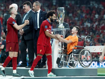 Foto del miércoles del delantero de Liverpool Mohamed Salah saludando a un niño durante la premiación de la Supercopa de Europa