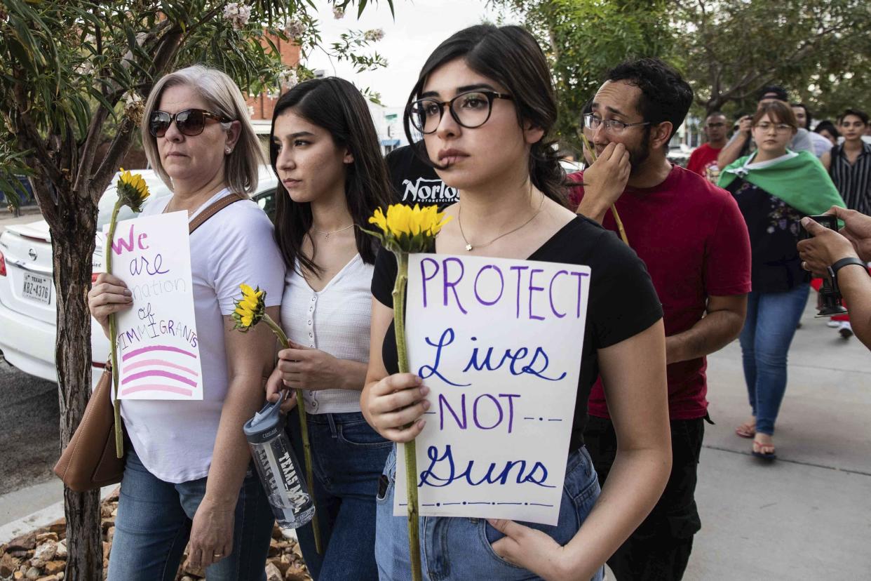 People march in silence Sunday, Aug. 4, 2019, holding sunflowers and sings in honor to the victims of a mass shooting occurred in Walmart on Saturday, Aug. 3, 2019, in El Paso, Texas. (Lola Gomez/Austin American-Statesman via AP)