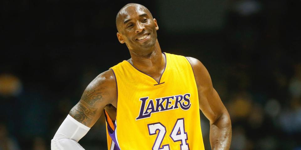 Kobe Bryant stands with his hands on his hips and smiles during a game ij 2014.