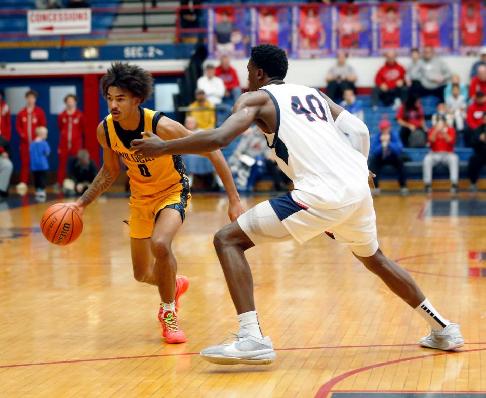 South Bend Riley senior Payton Baird (0) dribbles the ball while being defended by Kokomo senior Flory Bidunga during a boys basketball game Saturday, Dec. 23, 2023, at Kokomo High School.