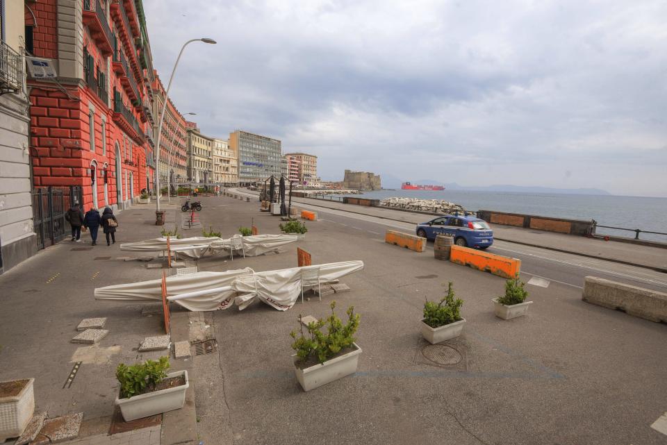 A police car patrol Naples' waterfront, Italy, Monday, March 8, 2021 following restriction measures to curb the spread of COVID-19. Italy surpassed 100,000 dead in the pandemic, a year after it became the first Western country to go on lockdown in a bid to stop the spread of COVID-19. The Health Ministry on Monday said 318 people had died in the last 24 hours, bringing the total to 100,103. (Alessandro Pone/LaPresse via AP)