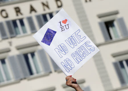 A woman holds up a placard ahead of a speech by Britain's Prime Minister Theresa May in Florence, Italy September 22, 2017. REUTERS/Max Rossi