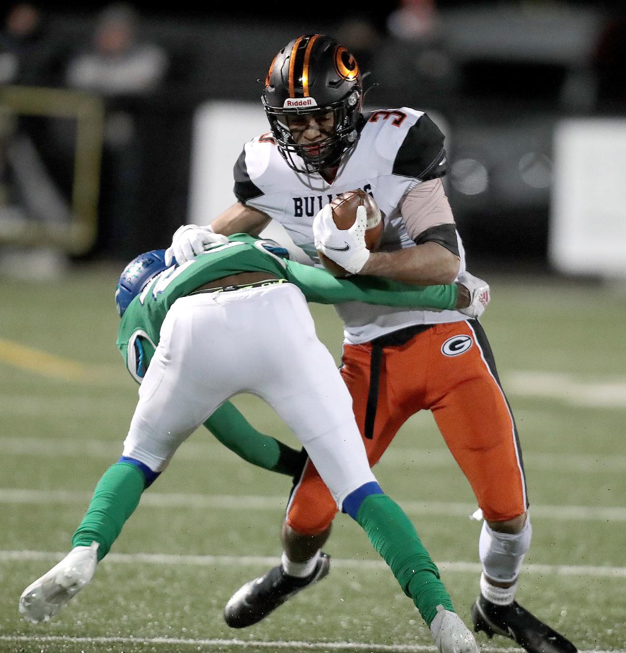 Green's Trey Martin works to get past Winton Woods defender Cameron Calhoun in the first half during this Division II football state semifinal at Westerville Central High School on Friday, Nov. 26, 2021.