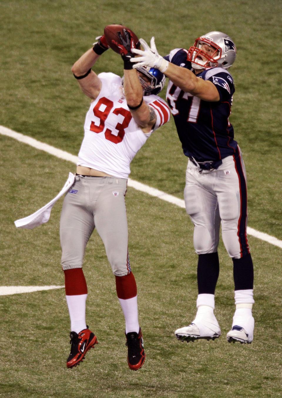 New York Giants linebacker Chase Blackburn (93) intercepts a pass from New England Patriots quarterback Tom Brady as Patriots tight end Rob Gronkowski (87) looks on NFL Super Bowl XLVI football game, Sunday, Feb. 5, 2012, in Indianapolis. (AP Photo/Charlie Riedel) ORG XMIT: SB395