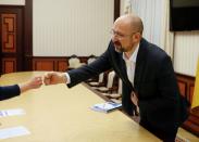 Ukraine's Prime Minister Shmygal greets a journalist during an interview in Kiev