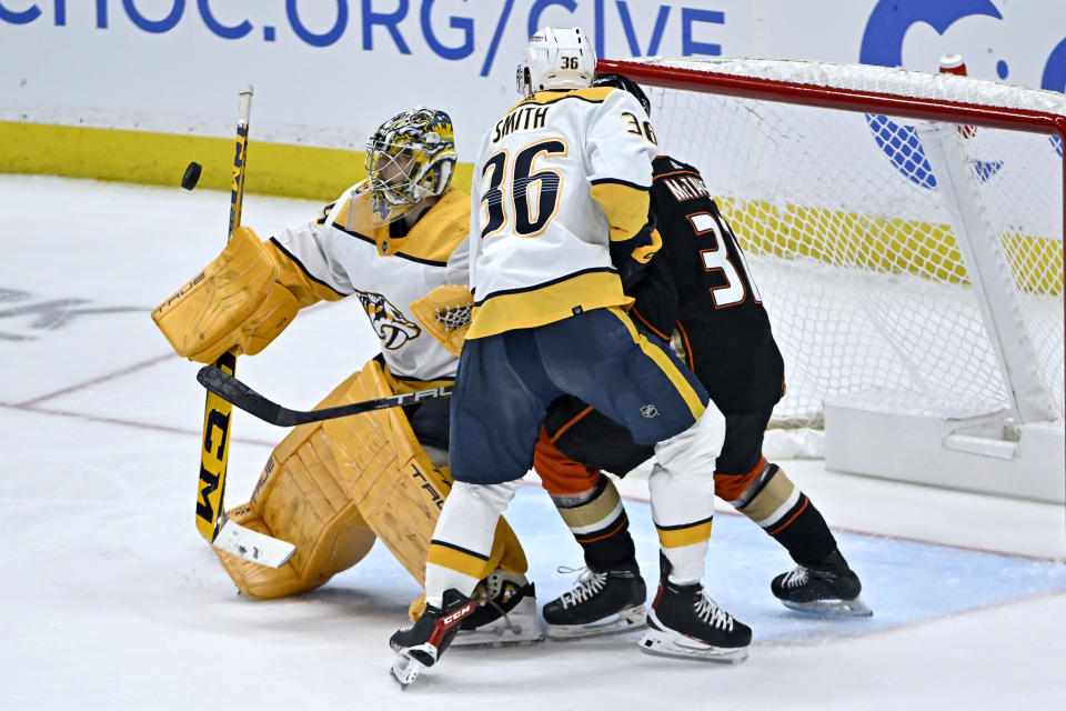 Nashville Predators goaltender Juuse Saros, left, blocks a shot, with Nashville Predators left wing Cole Smith (36) defending against Anaheim Ducks center Mason McTavish, right, during the third period of an NHL hockey game in Anaheim, Calif., Sunday, March 12, 2023. (AP Photo/Alex Gallardo)