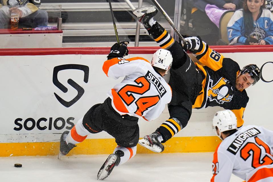 Pittsburgh Penguins' Dominik Simon (49) falls after a collision with Philadelphia Flyers' Nick Seeler (24) during the first period of an NHL hockey game in Pittsburgh, Thursday, Nov. 4, 2021.