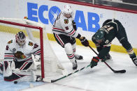 Minnesota Wild's Jordan Greenway, right, attempts a wrap-around shot against Chicago Blackhawks goalie Kevin Lankinen, left, who gets some defensive help from Connor Murphy during the first period of an NHL hockey game Saturday, Jan. 22, 2022, in St. Paul, Minn. (AP Photo/Jim Mone)