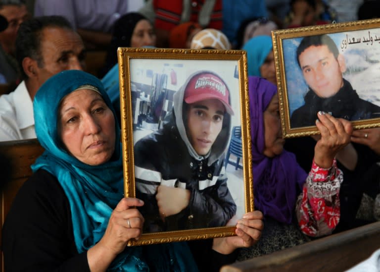 Families of victims of Tunisia's 2011 revolt against dictatorship carry portraits of their loved ones during a trial in Kasserine on July 13, 2018