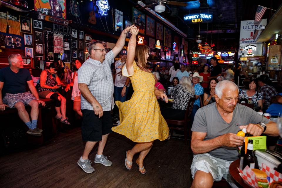 Michael Spratt, from Davenport, IA, and Laurie Montgomery, from Nashville, dance at Roberts Western World after storm delays shut down the outdoor stages during the 50th annual CMA Fest in Nashville, Tenn. on Sunday, June 11, 2023