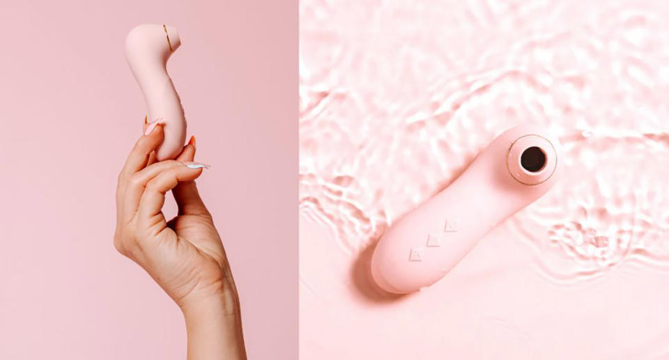 Pink vibrator sex toy being held in woman's hand and in water