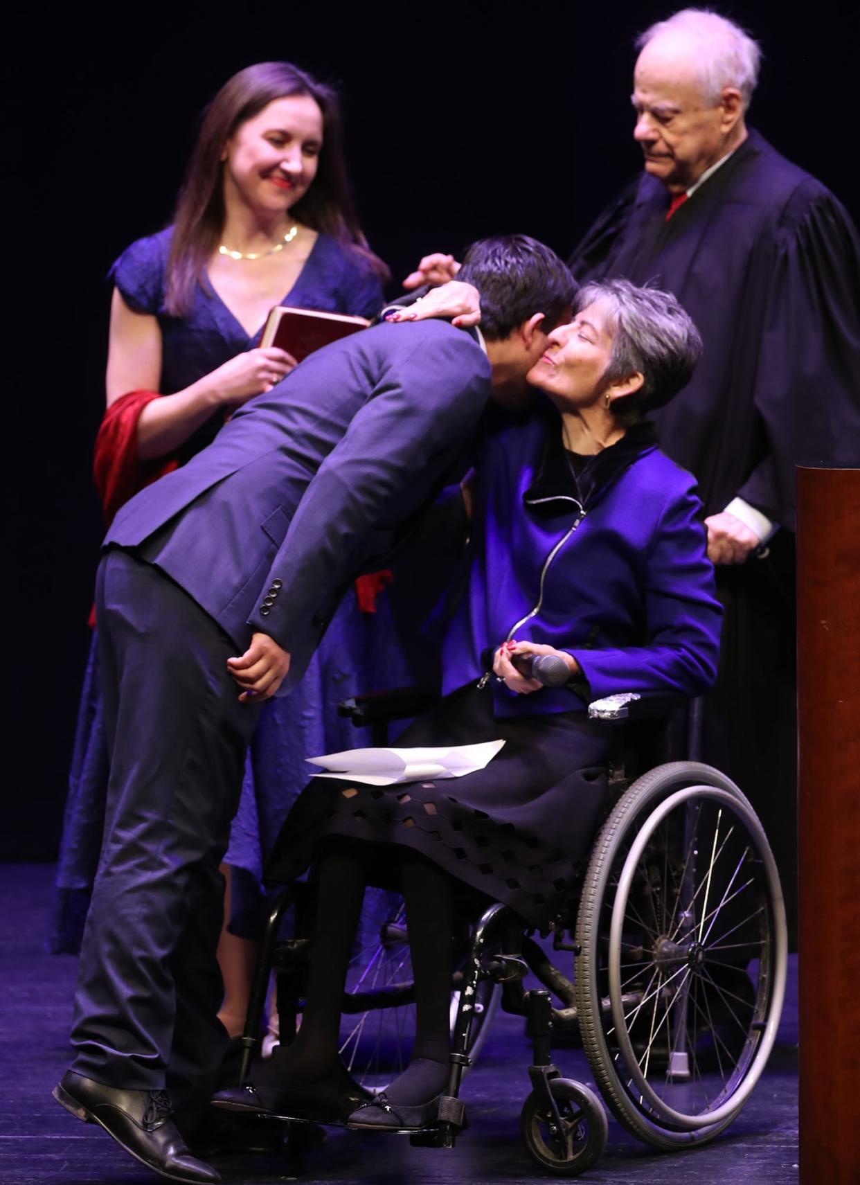 Akron Mayor Shammas Malik hugs his aunt Mary Theofanos as Alice Duey, back left, and retired Judge Ted Schneiderman look on after the ceremonial swearing-in during a public ceremony at EJ Thomas Hall on Saturday.