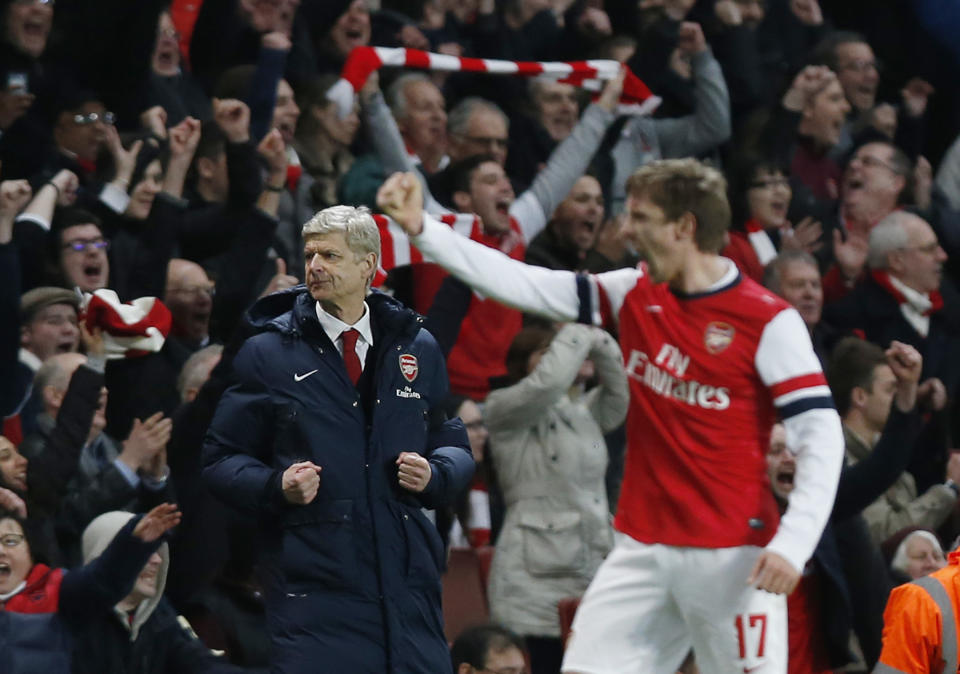 Arsenal's manager Arsene Wenger, left, celebrates their win against Liverpool at the end of their English FA Cup fifth round soccer match at Emirates Stadium in London, Sunday, Feb. 16, 2014. (AP Photo/Sang Tan)