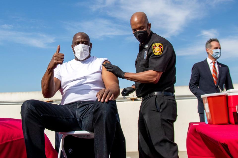 Magic Johnson (left) gives a thumbs-up after getting a vaccine last month, as a part of a vaccination awareness event at USC, in Los Angeles.