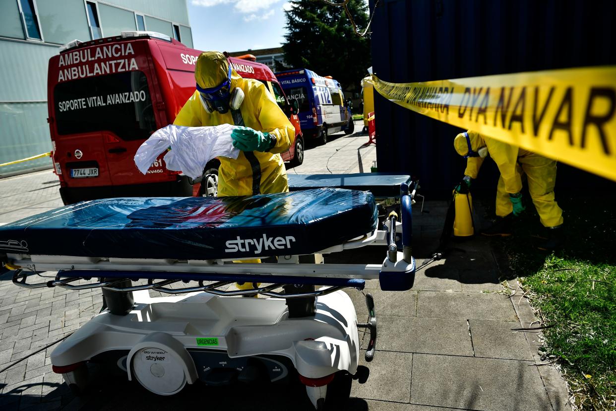 Volunteer workers of a regional search and rescue disinfect a stretcher with special equipment, close to Navarra Hospital, in Pamplona, northern Spain, on Thursday, March 26, 2020.