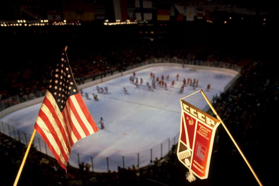 FILE - In this Feb. 22, 1980, file photo, an American flag and Soviet team banner are shown above the hockey rink where the the United States and Soviets played a medal round hockey match at the 1980 Winter Olympics in Lake Placid, N.Y. The United States upset the mighty Soviets in a breathtaking moment freighted with the tension of the Cold War. After four decades, nobody is willing to stop talking about perhaps the greatest David over Goliath moment in the history of sports. (AP Photo/File)